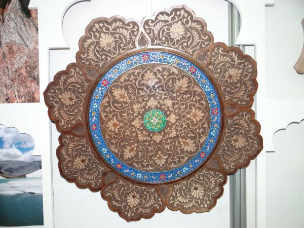 A carved and painted wooden plate